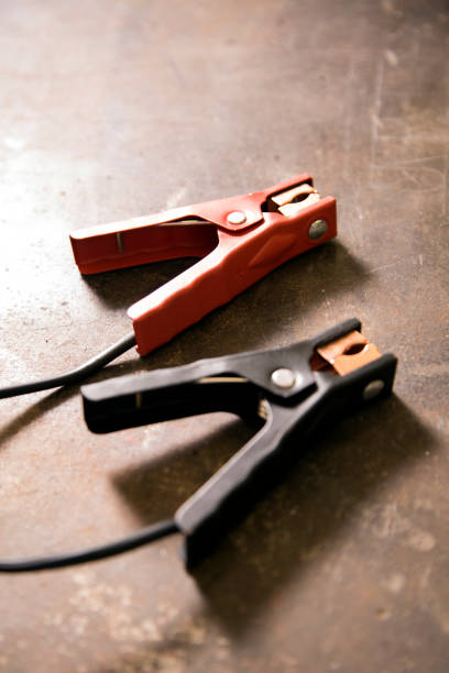 istock Battery charger clamps on metal work bench. 1312333221