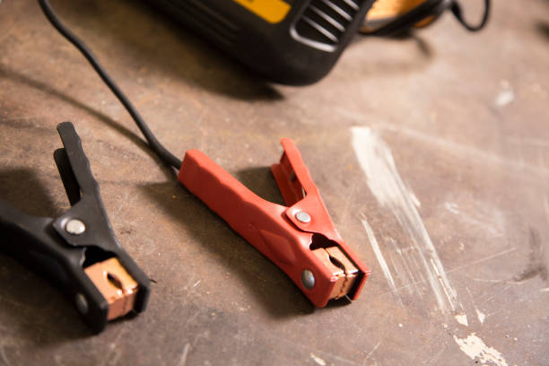 istock Battery charger clamps on metal work bench. 1312334047