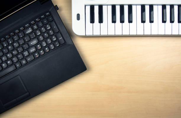 istock Computer laptop and electric synthesizer with keyboard on the table. Place for text 1312335193