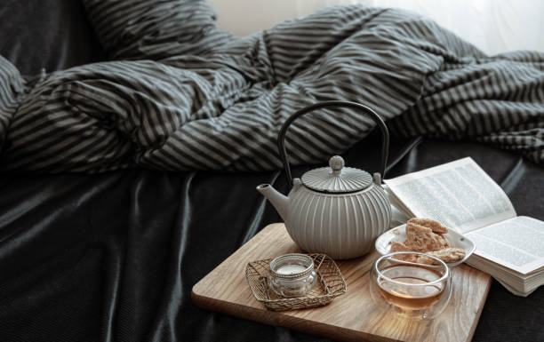istock Cozy still life with tea, cookies and a book in bed. 1312335548