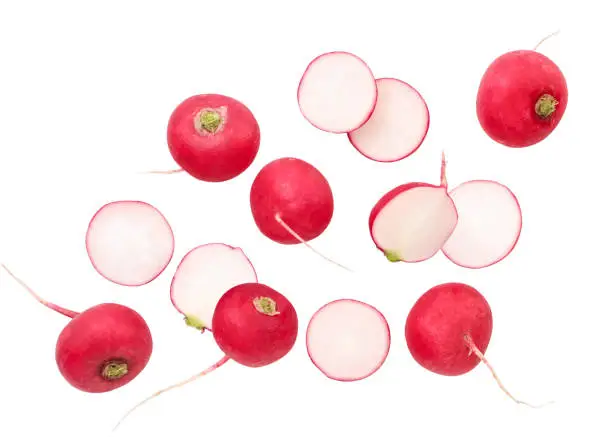 Fresh whole radish and pieces are flying close-up on a white background, radish levitating. Isolated