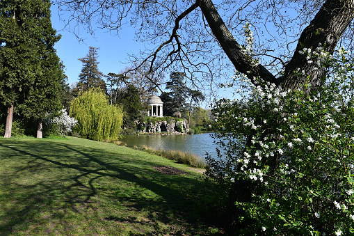 Paris, France-04 13 2021:The charming ambiance of the artificial lake of Daumesnil and the Temple of Sibylle on the Reuilly island in the middle of the lake, which is located within the Bois de Vincennes park in Paris.