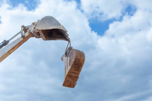 heavy excavator bucket under cloudy and blue sky in detail