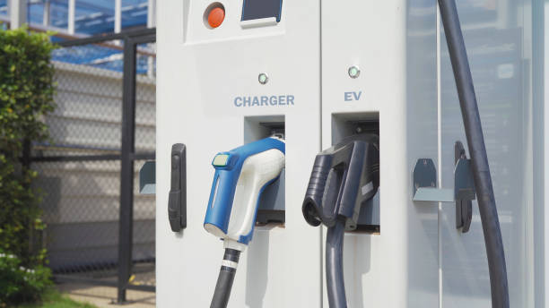 istock Hand pulling in cable from EV car charger or electric vehicle station. Cable connected at gas station, power supply battery charging an alternative eco environment future technology energy innovation 1312343458