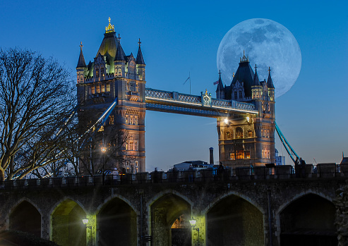 A full moon over the iconic Tower Bridge in London, UK