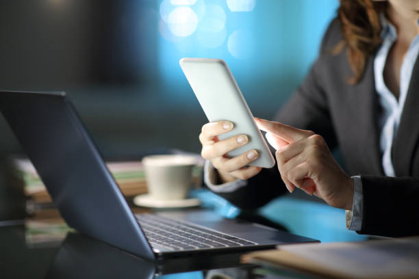 istock Self employed hands using phone and laptop in the night 1312345933