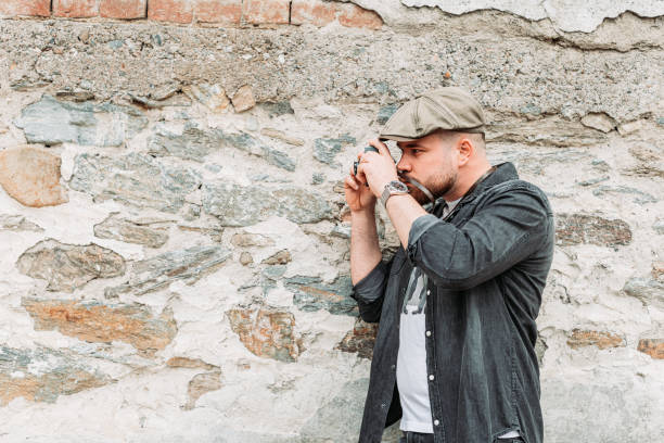 istock Young hipster man taking a photo with an old, retro camera. Copy space 1312346689