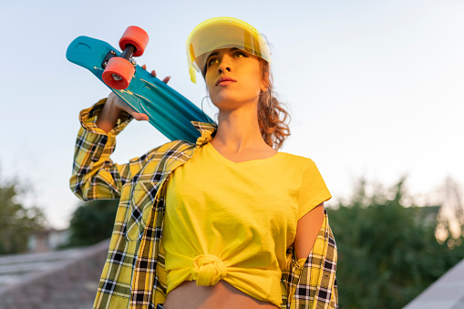 Young woman is posing with skateboard. freedom and independence youth concept.