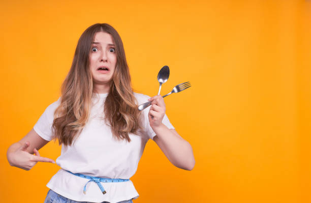 istock Young surprised girl with a fork and a spoon in her hands. 1312348293