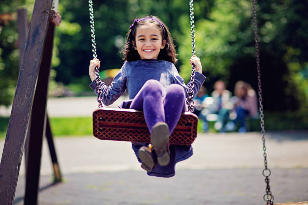 niña se balancea en un parque - child swing swinging spring fotografías e imágenes de stock