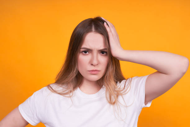 istock Young thoughtful girl on a yellow background. 1312349413