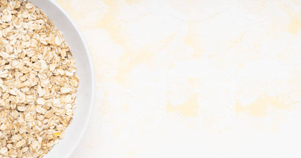 istock Oat flakes in a white plate on a yellow cement background 1312352996