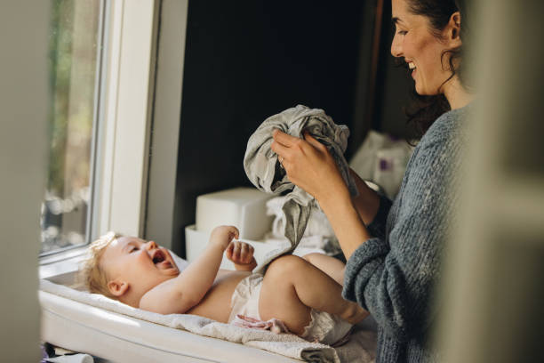 istock Mother getting her baby dressed 1312353244