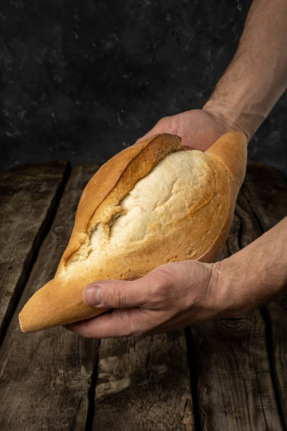 istock Freshly backed farmhouse bread on an old rustic wooden board. Retro style. 1312354143