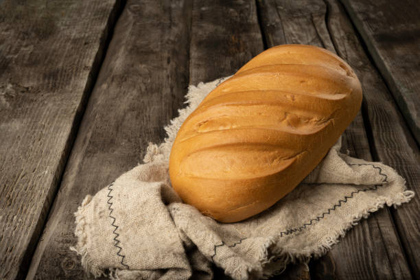 古い素朴な木製ボードに新鮮な農家のパン。レトロなスタイル。 - bread cereal plant black food ストックフォトと画像