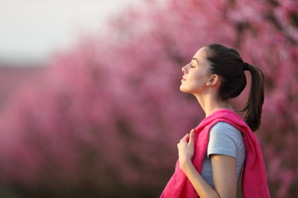 deportista respirando aire fresco después del deporte en un campo - exhalar fotografías e imágenes de stock