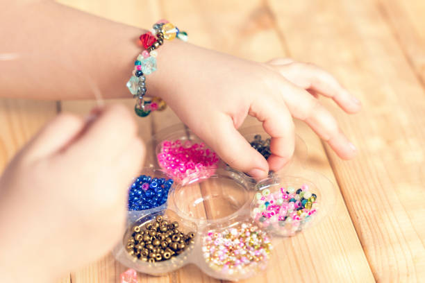 istock The child makes jewelry with his own hands, stringing colorful beads on a thread 1312356947