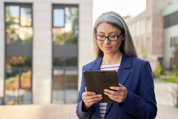 istock Concentrated grey-haired woman checking updates on her tablet 1312358097