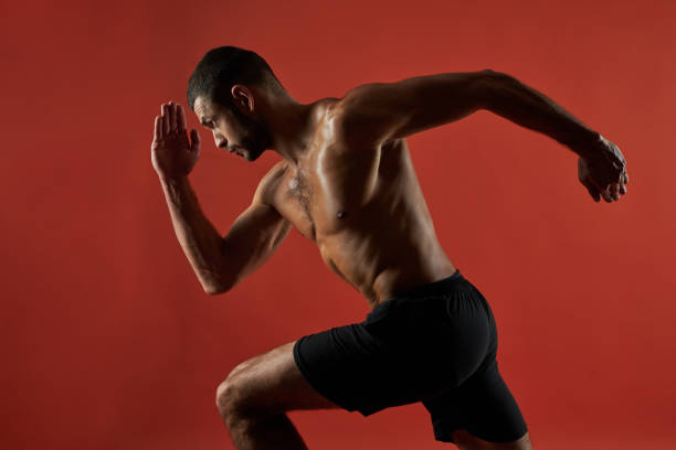istock Strong athlete with powerful torso in action isolated on red background of a studio 1312359630