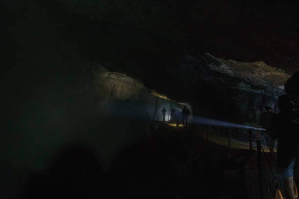 istock people walking in dark cave with flashlights 1312361879