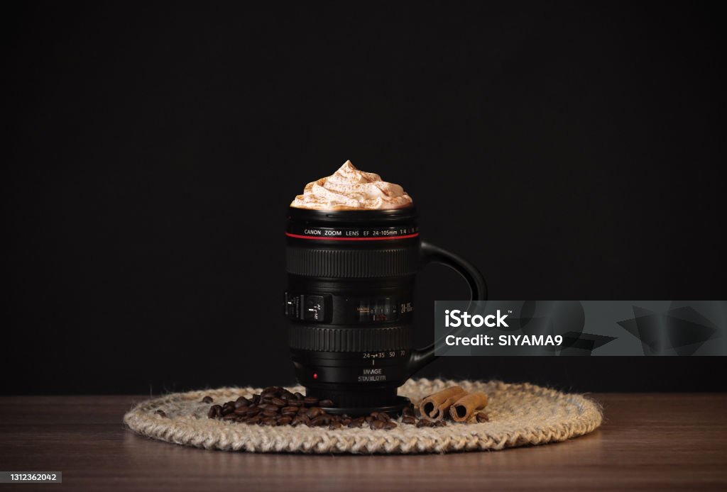 Canon Coffee Frappuccino A mug of frappuccino coffee in the image of a Canon lens. Lens - Optical Instrument Stock Photo
