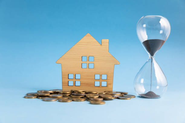 istock stack of coins with house model and hourglass 1312362119