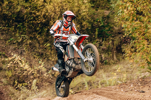 Unrecognized athlete racing with sports motorbike a motocross competition. Enduro extreme race sport.