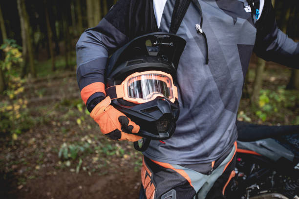male portrait of motocross enduro rider outdoors. sports concept for motorsport on sports track. professional biker with helmet and stunt motorcycle. man with protective sportswear. - motocross leisure activity sport motorcycle racing imagens e fotografias de stock
