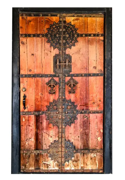 This is a front view of an old wooden door with an ornate metal pattern  isolated on a white background