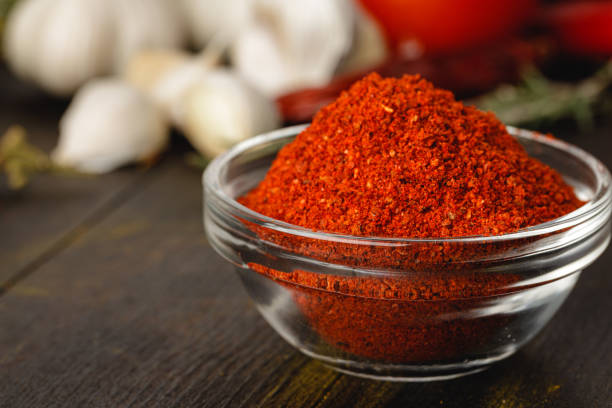 istock Red chili spice in glass bowl with herbs on dark table 1312370067