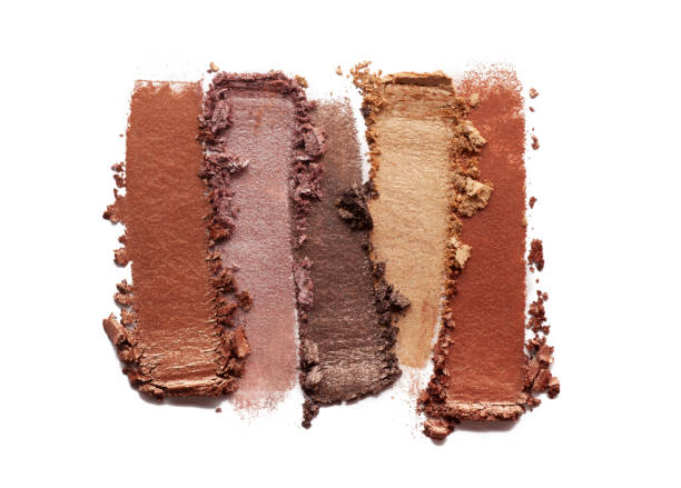 Smudged and crushed brown yellow gold orange loose shimmer textured eyeshadow on white background