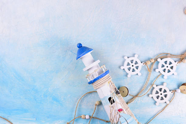 Flatlay comp with lighthouses and marine decorations on a blue background. Travelling abroad concept. Memorys background. Top view with copy space text