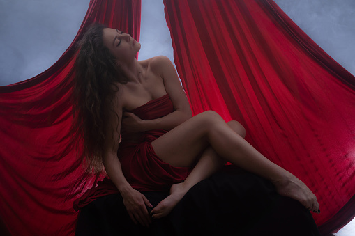 Gorgeous nude woman with red color silk.