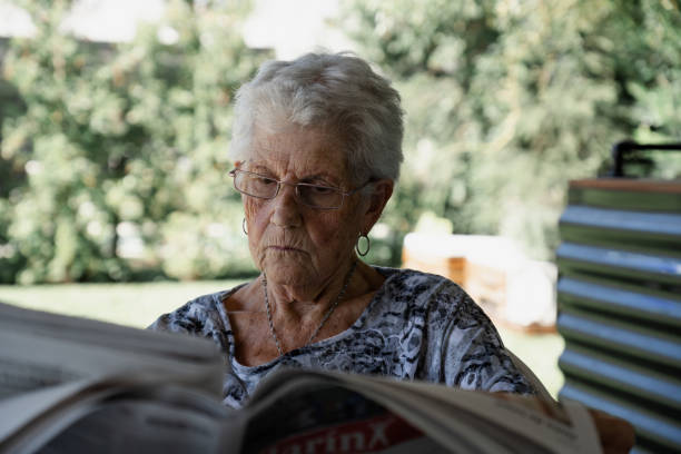istock old lady reading the newspaper sitting in the garden 1312377613