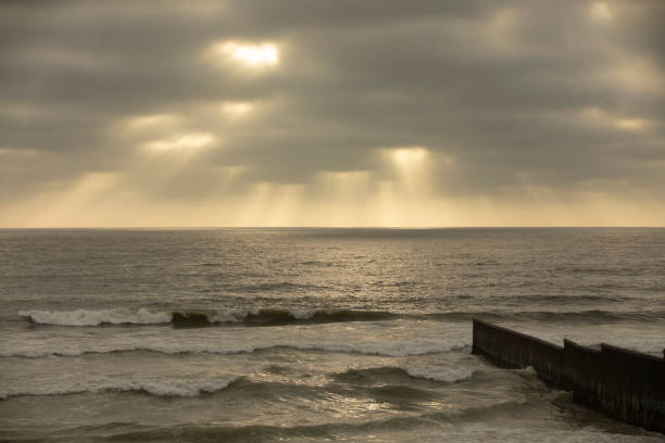 Rays of light bath the USA and Mexico border wall in Tijuana, Mexico.