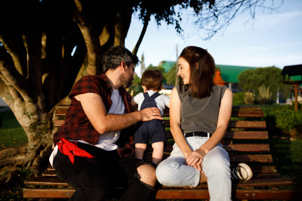 istock Parents and their son sitting on a wooden bench 1312382368