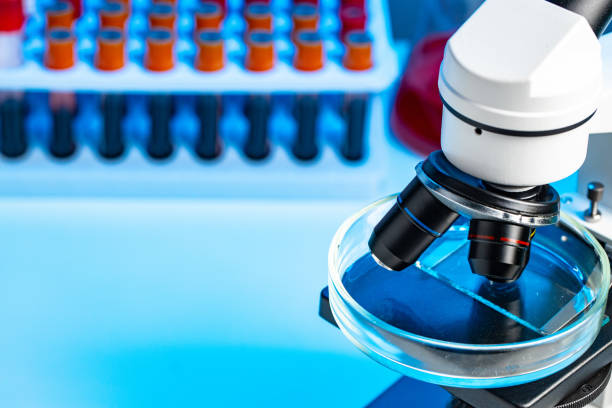 istock Close up photo of microscope with test tubes with blood samples 1312384674