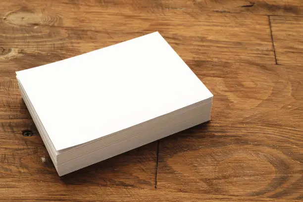 Blank businesscard stacks on rough wooden table, copy space