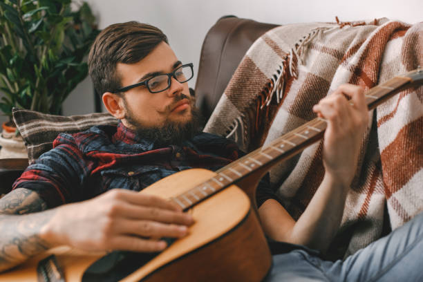 istock Young guitarist hipster at home lying playing guitar 1312386267