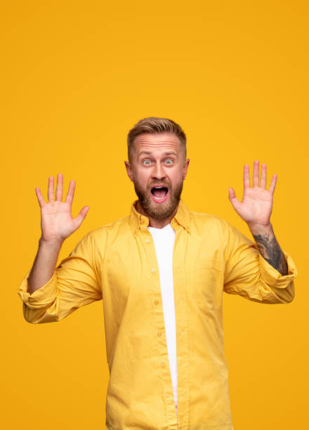 istock Surprised adult man with hands raised screaming in light studio 1312386399