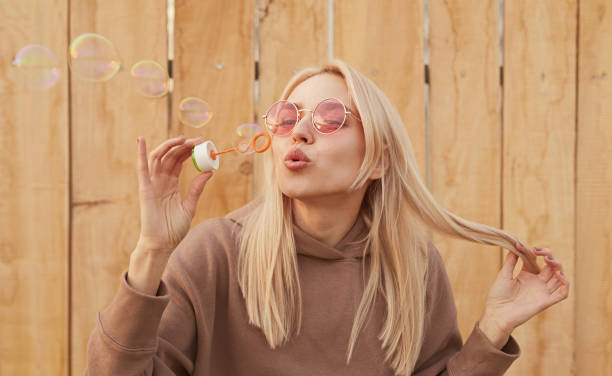 istock Content woman blowing bubbles in street 1312386455