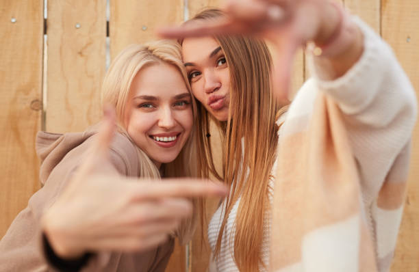 istock Joyful young women doing frame gesture and smiling at camera 1312386459