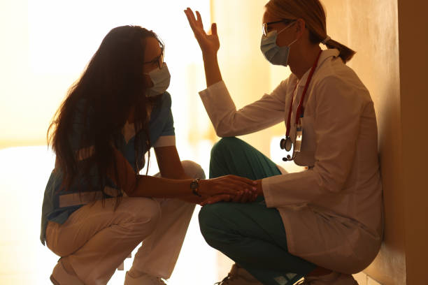 istock Two frustrated doctors in protective masks sit in hallway 1312386660