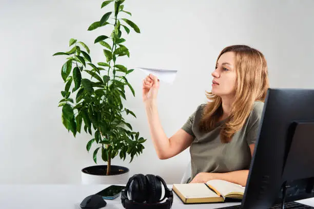 Photo of Woman hold paper plane while working at home office