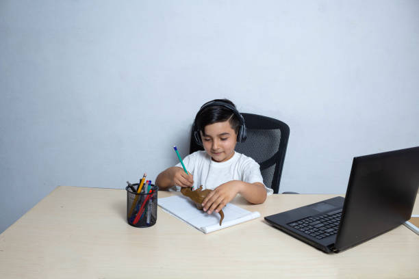 istock little Hispanic boy playing to draw his dinosaur on notebook 1312388596