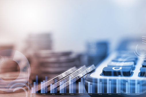 Row of coins, financial graph and calculator with blank space for finance background, accounting and business investment concept