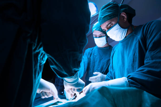 skoncentrowany profesjonalny zespół lekarzy chirurgicznych operacyjnych chirurgii pacjenta na sali operacyjnej w szpitalu. opieki zdrowotnej i koncepcji medycznej. - surgeon doctor operating room emergency room zdjęcia i obrazy z banku zdjęć