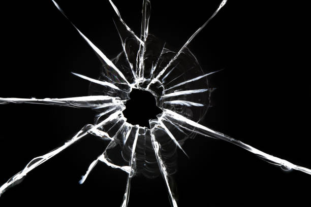 istock Cracked glass on a black background. Broken window. Bullet hole, abstraction for design 1312406022