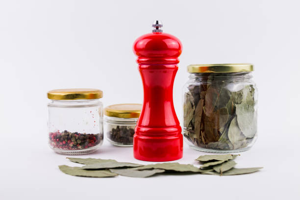 a bay leaf and peppercorns in glass jars