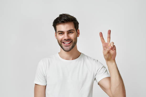 istock Bearded man wearing t-shirt showing peace gesture 1312407727